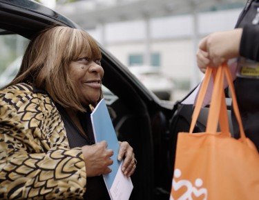 Older African American woman grabbing a bag of supplies
